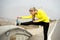 Sport woman stretching leg muscle after running workout on asphalt road with dry desert landscape in hard fitness training session