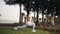 Sport woman in white sportswear performing yoga pose or stretching outdoors. Athletic girl stretching in park. Fitness