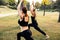 Sport women doing yoga outside in morning. Fitness girls relax in park