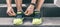 Sport workout fit runner man getting ready to run tying shoe laces panoramic banner. Athlete going to gym wearing