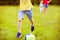 Sporting boy plays football in sunny park