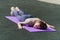 Sporting a tired young girl lies face down on a yoga mat