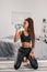 sportive african american woman drinking water after workout at home while standing