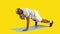 Sportive african man doing shoulder plank on a mat