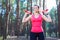 Sportive attractive girl working out with dumbbells, training in the forest. Fitness, sport, lifestyle concept