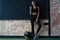 Sportive caucasian cross fit woman with fitness ball stand in gym, look at camera