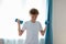 Sportive child boy exercising with dumbbells at home