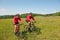 Sportive couple riding bike in summer meadow