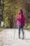 Sportive cute woman Nordic walking autumn cross country