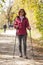 Sportive cute woman Nordic walking autumn cross country