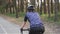 Sportive cyclist woman riding a bicycle in the park. Back side follow shot. Cycling concept