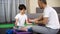 Sportive dad teaching his son to make dumbbells exercise at home, muscles power