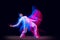 Sportive, emotional man, dancer dancing hip-hop isolated on dark background in mixed neon light. Youth culture, hip-hop