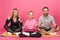 sportive family showing thumbs up while sitting on fitness mat, isolated