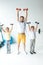 sportive father and sons holding dumbbells in raised hands and smiling