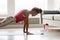 Sportive girl doing push press ups exercise at home