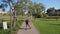 Sportive girl on roller skates. Driving on asphalt in a green park. Front view.