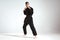 Sportive guy trainer in black kimono fighter posing in karate stance on studio background with copy space