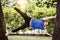 Sportive man in side plank among trees