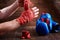 Sportive man wrapping his hands with bandage and boxing gloves on wooden plank.