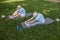 Sportive mature family couple does head to knee exercises sitting in park on summer day