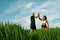 Sportive People`s Giving High Five Among Green Grass Portrait. Caucasian Man And Asian Woman Standing On Paddy Field.