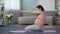 Sportive pregnant mommy doing physical exercises, accustoming baby to sport