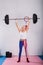 sportive senior woman in patriotic sportswear holding barbell and smiling