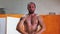 Sportive training - a shirtless man squatting with a weight in his hands