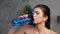 Sportive woman drinks water from after intense fitness workout exercise at home