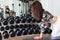 Sportive woman with slim body doing exercise with dumbbell