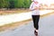 Sportive woman wears protective mask on face jogging for good health on road beside irrigation canal due to the corona virus