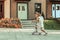 Sportive young girl in white dress actively riding on a skateboard