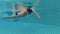 Sportive young man swimming crawl style in swimming pool, underwater view. Vacation. Action camera