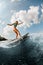 sportive young woman wakesurfer riding on blue splashing wave on a warm day
