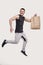 Sportman Holding Food Bag. Man with Paper Bag in Hands. Healthy Eating, Healthy Food, Sport Concept. Sport man Jumping