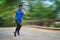 Sportman runner practicing sprinting run on road in park in morning