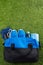 sports background. on the green lawn, are blue items for fitness outdoor, sneakers and a bag