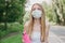 Sports blonde girl in a white medical mask jogging in the park  healthy lifestyle during quarantine covid-19