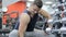 Sports bodybuilder young man hard training biceps muscles in gym