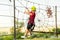 A sports boy on a cable car with obstacles in an extreme park overcomes difficulties