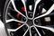 Sports car alloy wheel with red calipers and brakes. Racing brake disc and low profile tyres. Car Shopping and Test Driving. Lower