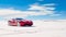 sports car in a stunning desert landscape with expansive blue skies above.