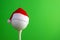 Sports concept on the topic of golf, Christmas and New Year. White golf-ball in a red Santa Claus hat set on a tee. Green