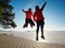 Sports couple crazy jumping on park path around frozen lake