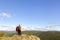 Sports couple sits on a high cliff over the white river and the Ural mountains on a summer sunny day