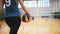 Sports for disabled people. A young woman trainer walks to her ward holding a volleyball ball and sit down on the floor