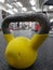 Sports equipment. Yellow kettlebell on the dark rubber