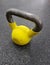 Sports equipment. Yellow kettlebell on the dark rubber