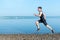 Sports, Fitness. Fit man running workout jogging at beach. Outdoors training.